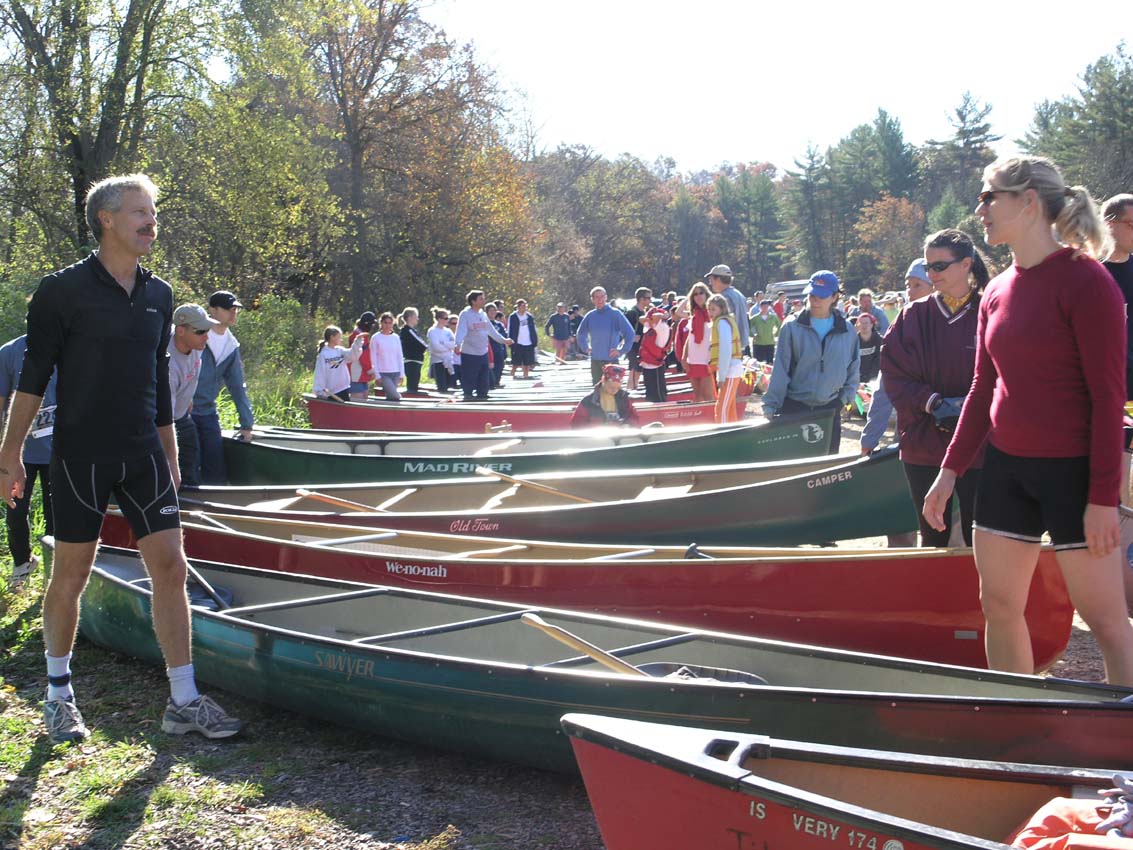 People lined up by canoes